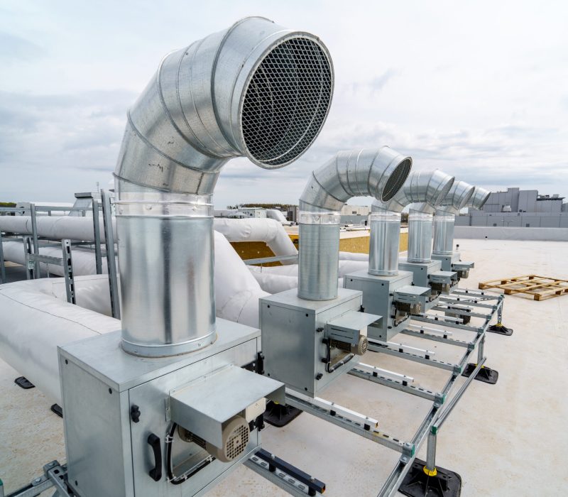 The air conditioning and ventilation system of a large industrial building is located on the roof. It consists of air ducts, air conditioning, smoke removal and ventilation